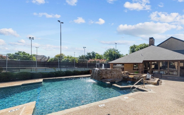 view of pool featuring pool water feature and a patio