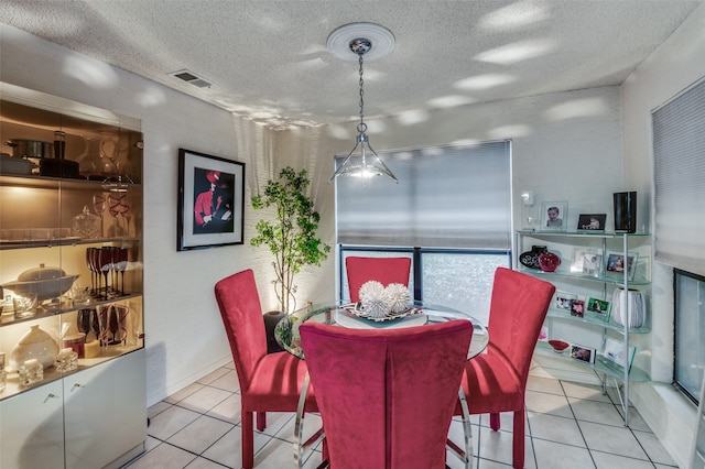 tiled dining area with a textured ceiling