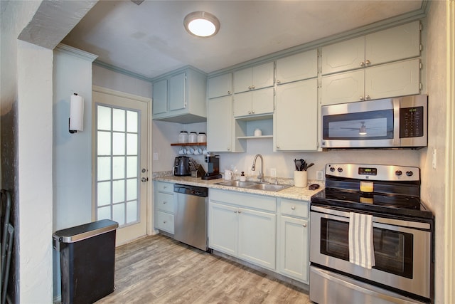 kitchen featuring stainless steel appliances, white cabinetry, sink, light hardwood / wood-style flooring, and crown molding