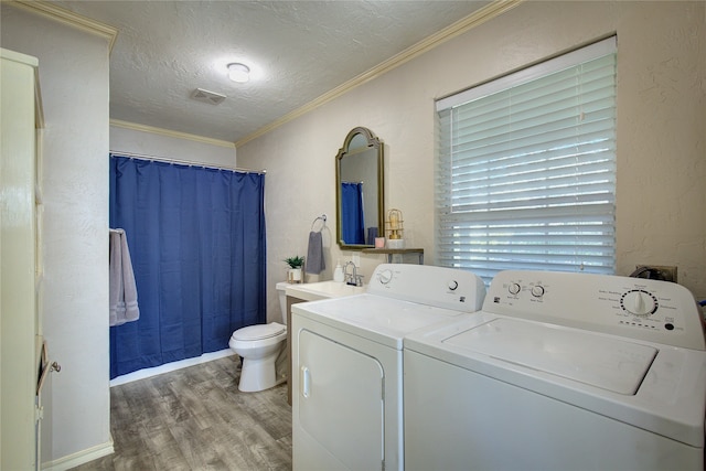 washroom featuring ornamental molding, washer and clothes dryer, a textured ceiling, sink, and hardwood / wood-style floors