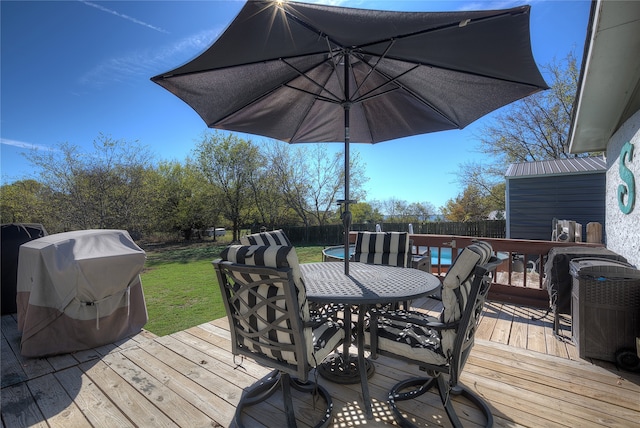 wooden terrace featuring grilling area and a lawn