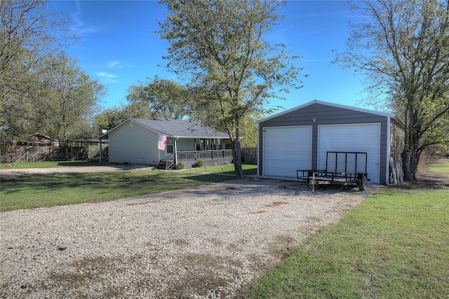 garage with a porch and a lawn