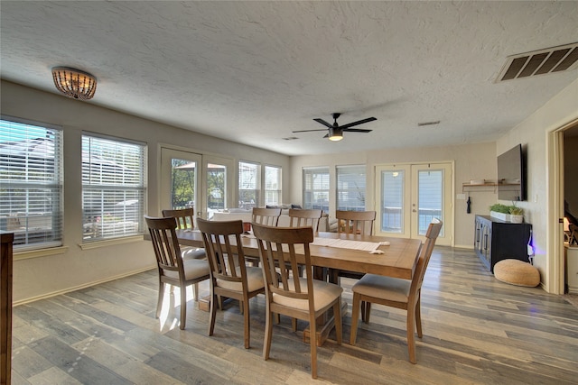 dining area featuring a textured ceiling, french doors, dark hardwood / wood-style floors, and ceiling fan