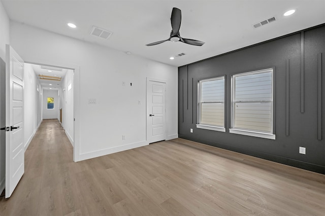 spare room with light wood-type flooring and ceiling fan