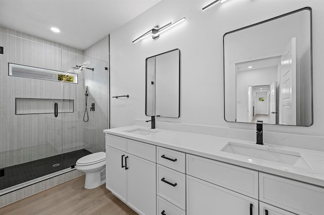 bathroom featuring toilet, vanity, wood-type flooring, and walk in shower