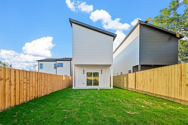 rear view of property featuring a lawn