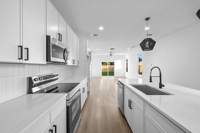 kitchen featuring light hardwood / wood-style flooring, white cabinetry, sink, and stainless steel appliances