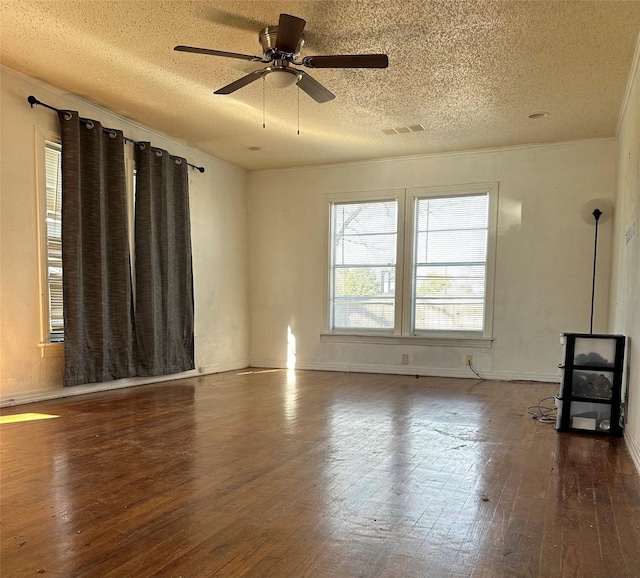 unfurnished living room with ceiling fan, a wood stove, a textured ceiling, and dark hardwood / wood-style flooring