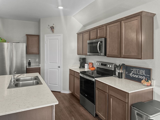 kitchen featuring dark hardwood / wood-style floors, sink, appliances with stainless steel finishes, and vaulted ceiling