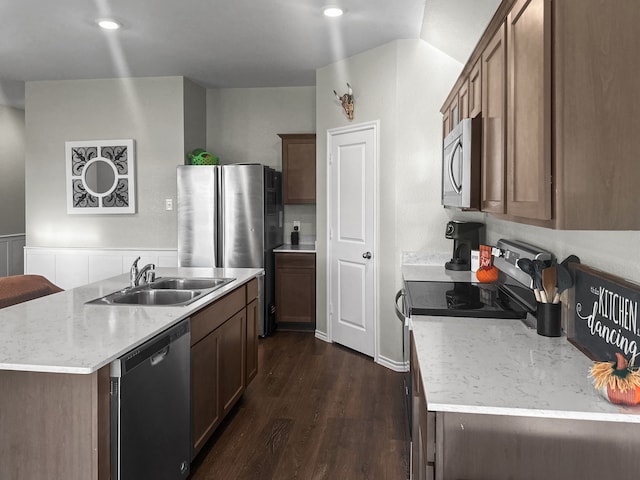 kitchen with dark hardwood / wood-style flooring, sink, stainless steel appliances, and a kitchen island with sink