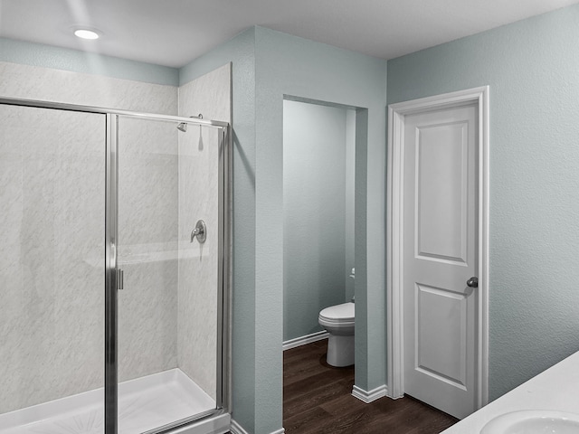 bathroom with hardwood / wood-style flooring, toilet, an enclosed shower, and vanity