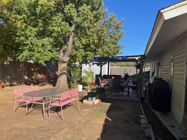 view of yard with a patio, outdoor dining area, and a fenced backyard