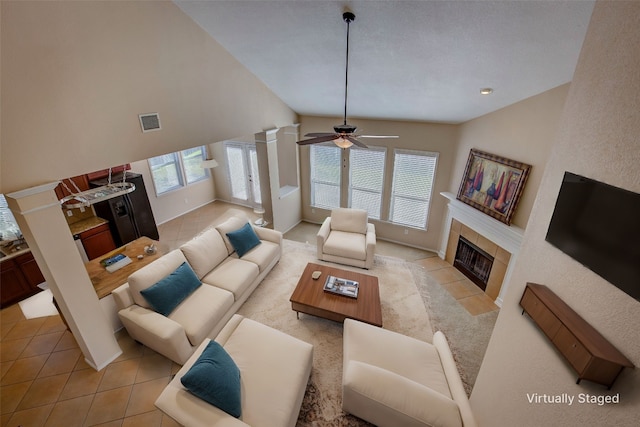 living room with light tile patterned flooring, decorative columns, ceiling fan, and a fireplace