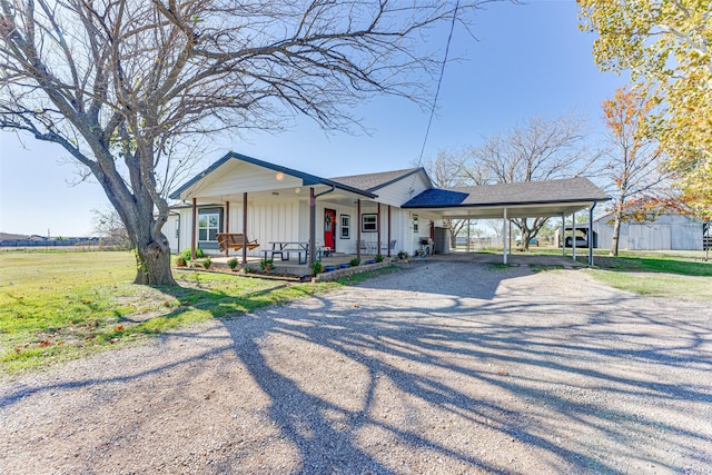 ranch-style house with a front lawn, a porch, and a carport