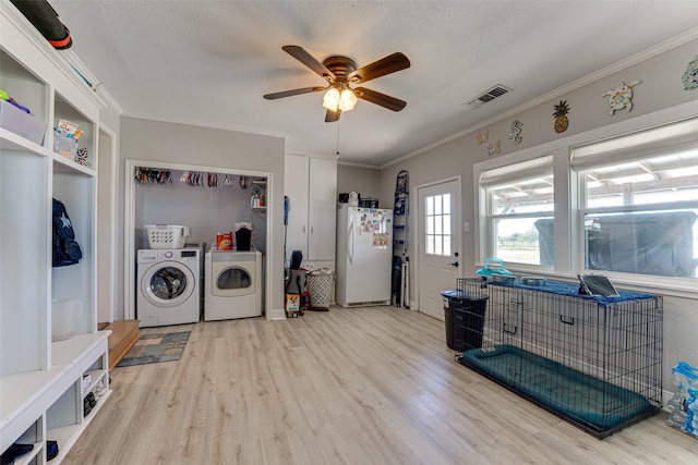 washroom with hardwood / wood-style floors, washing machine and clothes dryer, ceiling fan, a textured ceiling, and ornamental molding