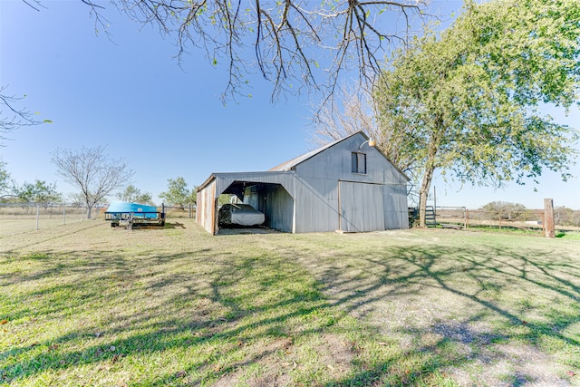 view of yard with a rural view, an outdoor structure, and a carport