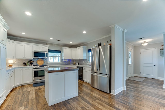 kitchen featuring white cabinets, backsplash, dark hardwood / wood-style flooring, and stainless steel appliances