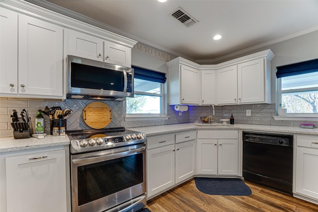 kitchen with appliances with stainless steel finishes, white cabinetry, and sink