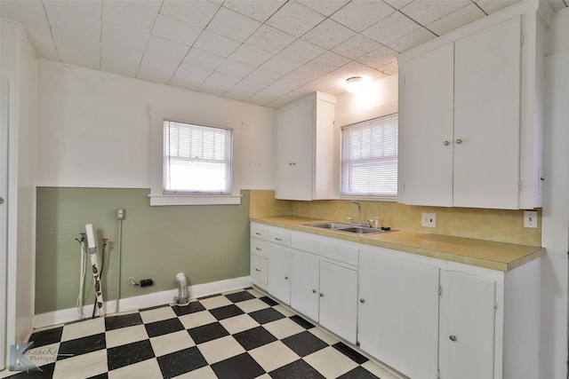 kitchen featuring white cabinetry and sink