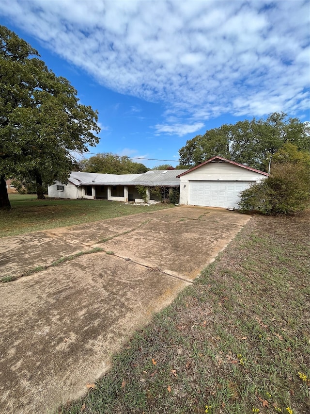 ranch-style house featuring a garage and a front lawn