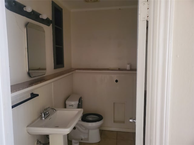 bathroom featuring toilet, sink, and tile patterned flooring