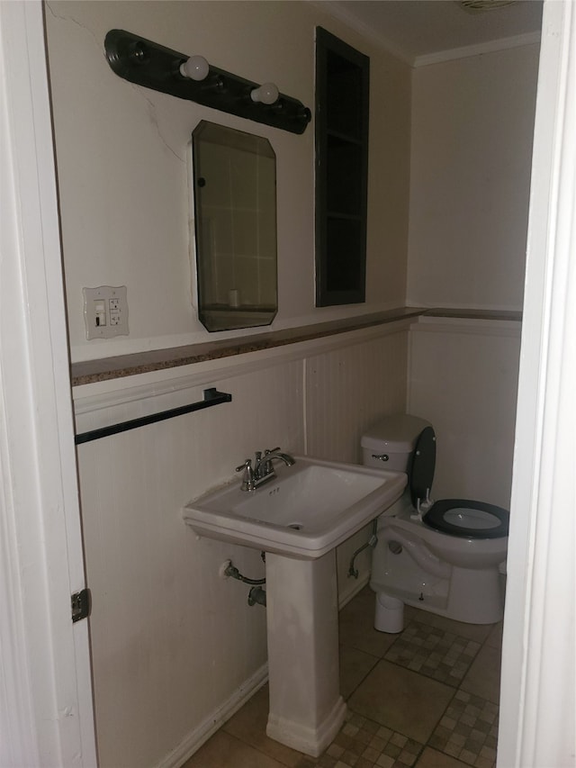 bathroom with toilet, tile patterned floors, and ornamental molding