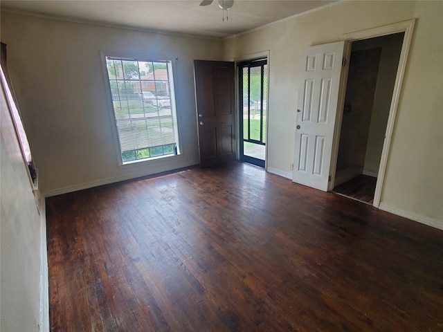 unfurnished room featuring dark hardwood / wood-style flooring, ornamental molding, and ceiling fan