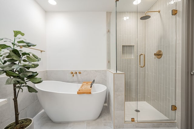 bathroom featuring tile walls and plus walk in shower