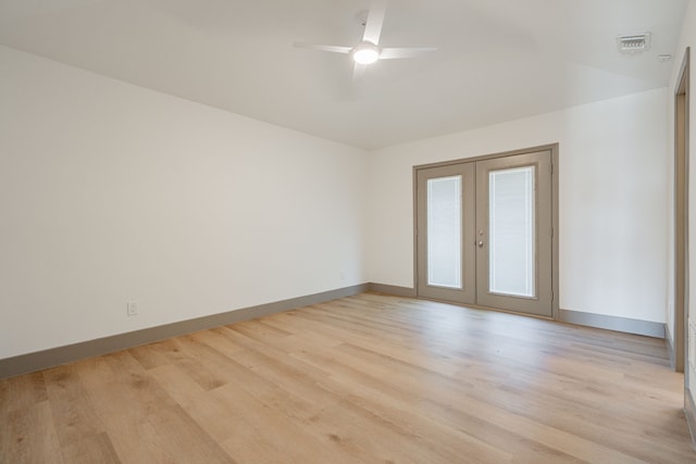 spare room featuring light hardwood / wood-style flooring, french doors, ceiling fan, and vaulted ceiling