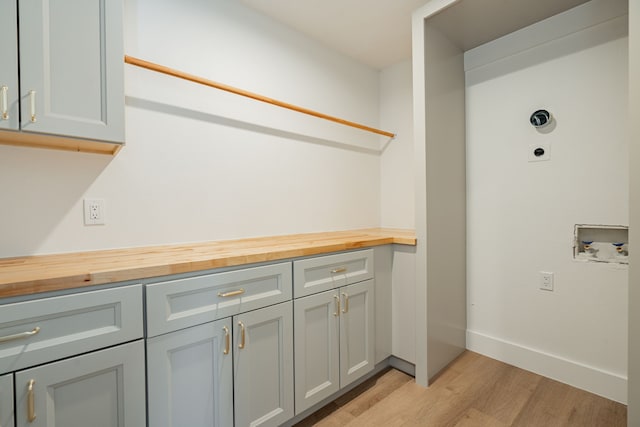 laundry room featuring hookup for a washing machine, electric dryer hookup, cabinets, and light wood-type flooring