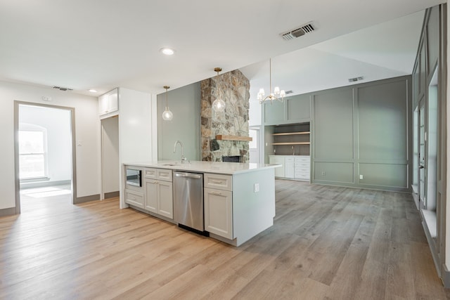 kitchen with pendant lighting, appliances with stainless steel finishes, white cabinets, kitchen peninsula, and light wood-type flooring