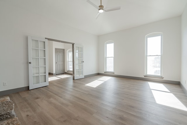 unfurnished room with french doors, ceiling fan, and light hardwood / wood-style flooring