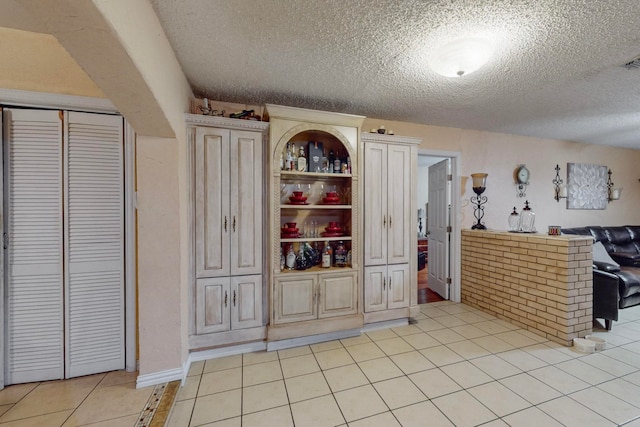 kitchen with a textured ceiling and light tile patterned flooring