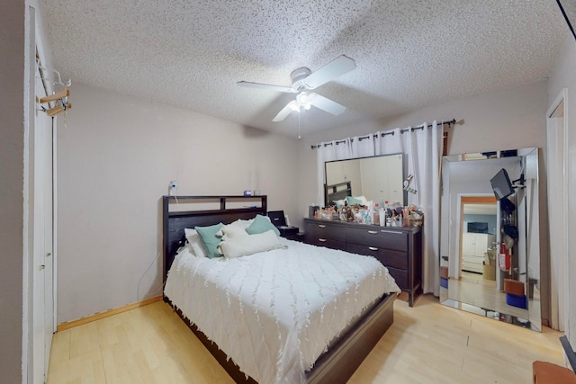 bedroom with a textured ceiling, light wood-type flooring, and ceiling fan