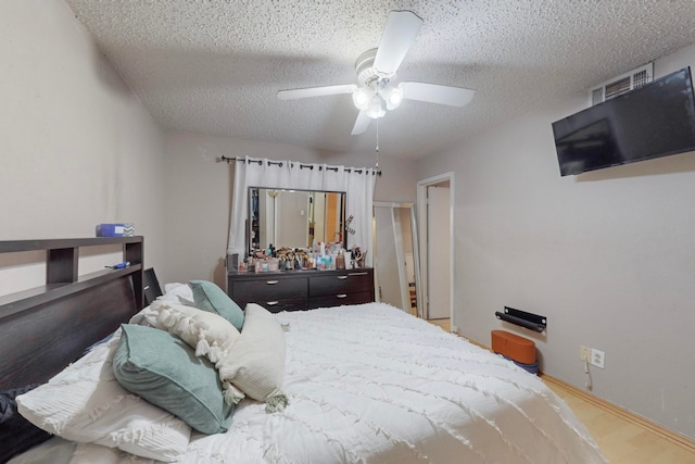 bedroom with a textured ceiling and ceiling fan