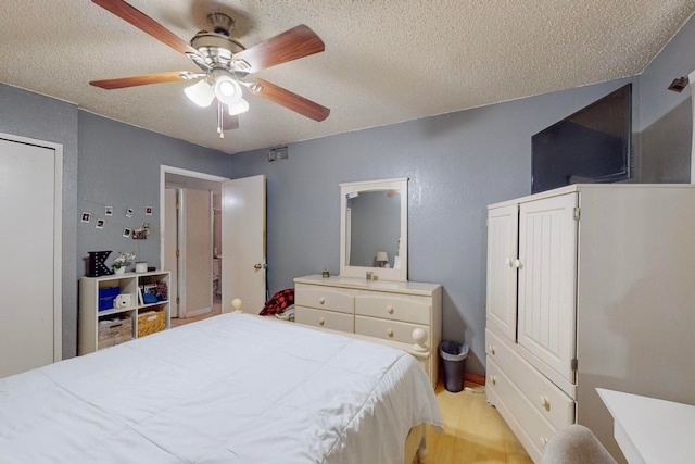 bedroom featuring a textured ceiling, light hardwood / wood-style flooring, and ceiling fan