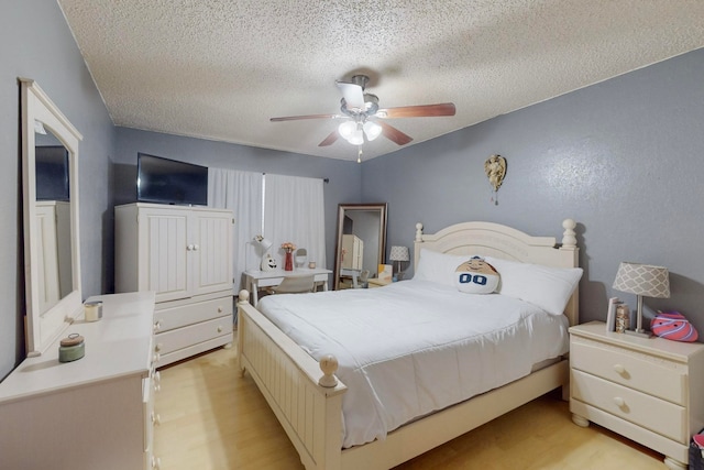 bedroom featuring ceiling fan, a textured ceiling, and light wood-type flooring