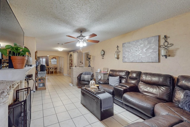 tiled living room featuring a textured ceiling and ceiling fan