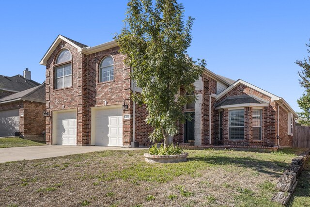 front facade with a garage, a front yard, and central AC