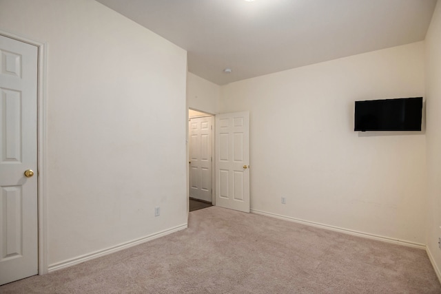 spare room featuring light colored carpet