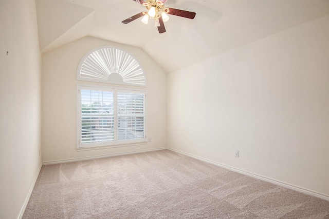 carpeted spare room featuring lofted ceiling and ceiling fan