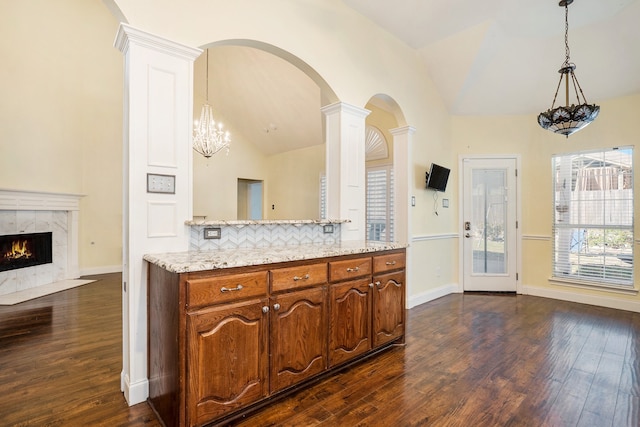 kitchen with tasteful backsplash, pendant lighting, vaulted ceiling, and dark hardwood / wood-style floors