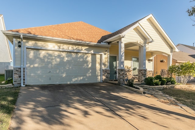 view of front of home with covered porch, a garage, and central air condition unit