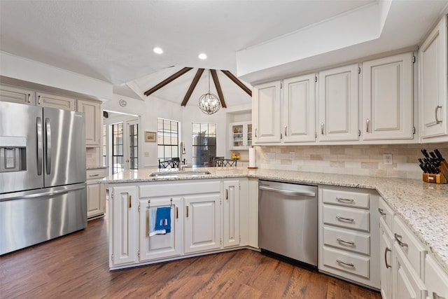 kitchen with stainless steel appliances, white cabinetry, sink, dark wood-type flooring, and kitchen peninsula