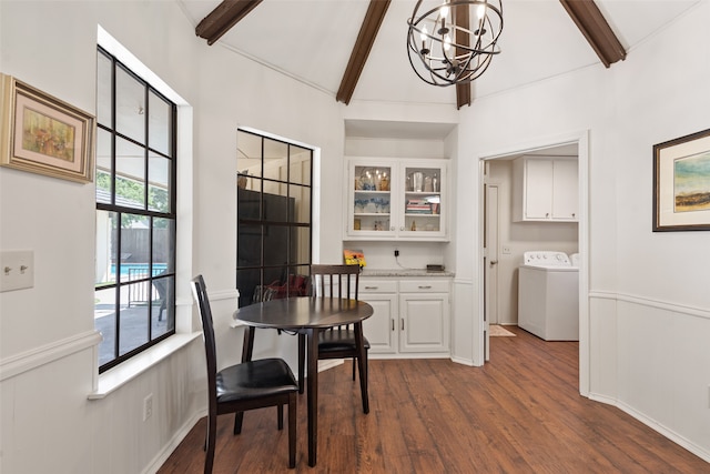 dining room featuring dark wood-type flooring, a chandelier, washer / clothes dryer, and lofted ceiling with beams