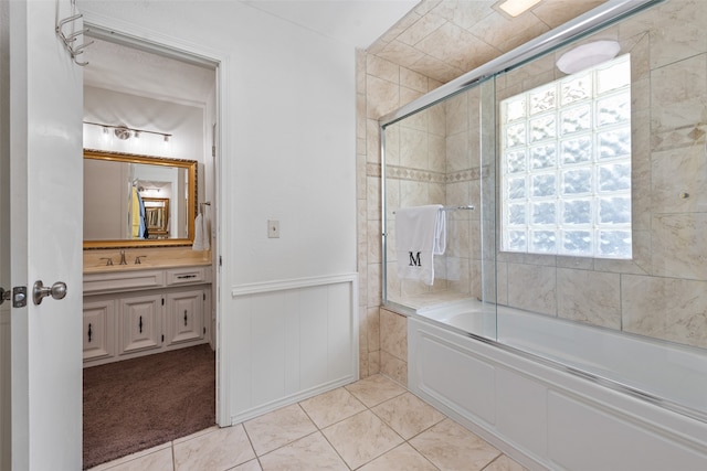 bathroom with bath / shower combo with glass door, vanity, and tile patterned flooring