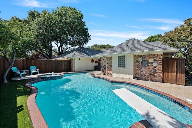 view of pool with a diving board, a patio, and an in ground hot tub