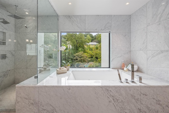 bathroom with shower with separate bathtub and plenty of natural light