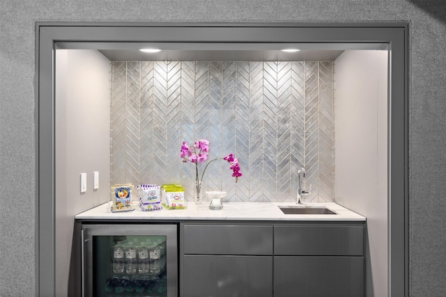 bar with gray cabinets, wine cooler, and sink