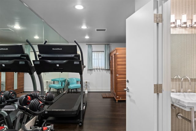 gym with dark hardwood / wood-style floors and sink